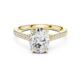 Front angle of an elongated oval cut main stone set in 14k gold with a micro pave band and claw prongs. Ideal as an engagement ring or anniversary gift, fully customizable in 10k/14k gold, 925 silver, or platinum with stone options from 1ct to 2ct in moissanite or lab grown diamond.