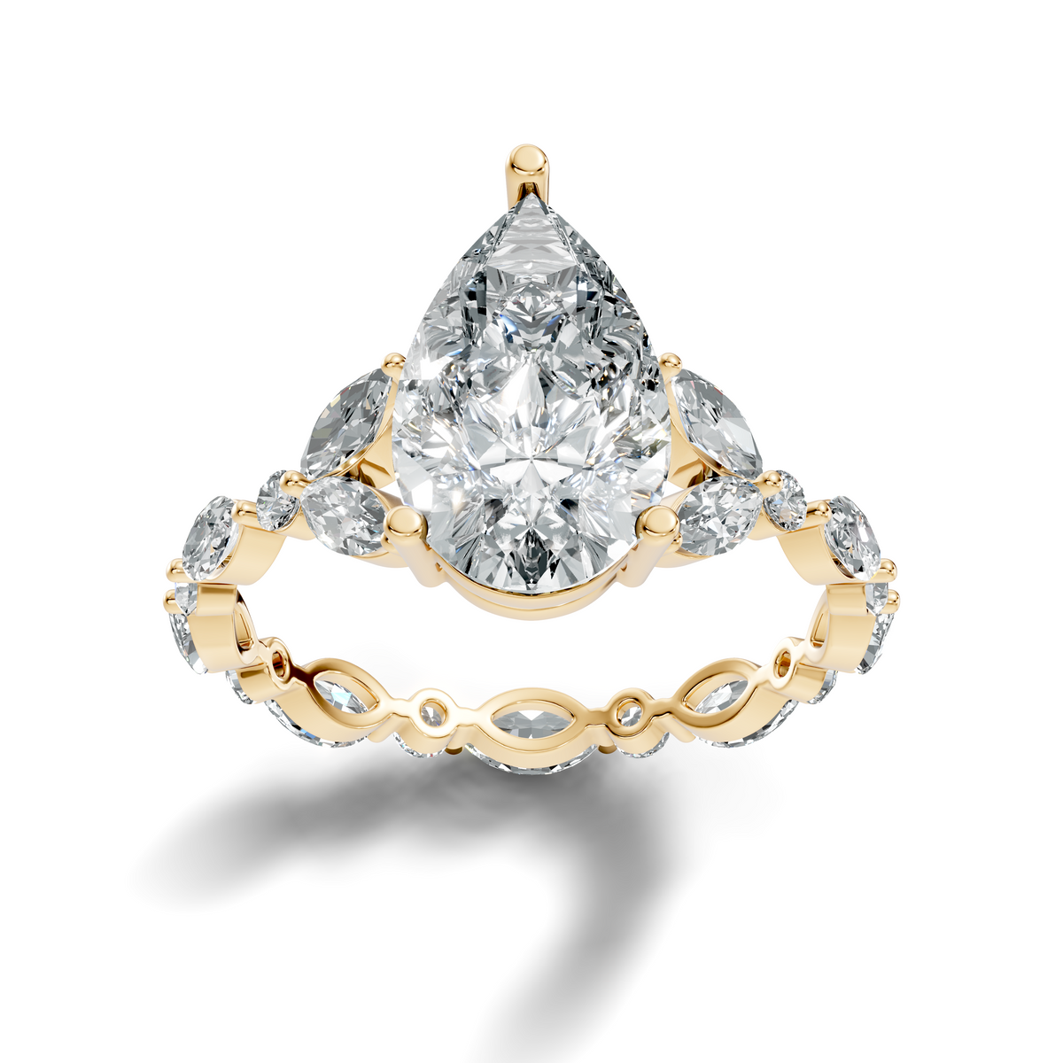 Front view of a brilliant pear cut Moissanite in 14k yellow gold 3-prong basket setting. Showcases top-tier colorlessness and symmetry on an accent band. Perfect choice for an engagement ring or anniversary gift. Custom options include 10k/14k gold, 925 silver, platinum with 1ct to 2ct moissanite or lab grown diamond centers.