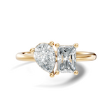 Front view showing a Toi et Moi two-stone setting with a pear cut and radiant cut stone held by secure basket prongs on a sleek rose gold band. Custom made in 925 silver, 10k or 14k gold, and platinum options. Perfect as an engagement ring or anniversary gift with customizable 1ct to 2ct moissanite or lab grown diamond.