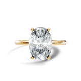 Front view showcasing an elongated oval cut center stone set on a delicate polished 14k gold band. Custom made in 925 silver, 10k gold, or platinum options. Classic engagement ring or anniversary gift featuring customizable 1ct to 2ct moissanite or lab grown diamond centers.